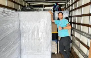 a serene and organized international moving scene unfolds in a spacious, sunlit room, highlighting a well-dressed professional confidently discussing relocation plans with a satisfied family, surrounded by labeled boxes and a world map on the wall, symbolizing a smooth transition across borders.